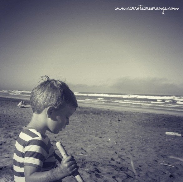 A young boy sitting on the beach