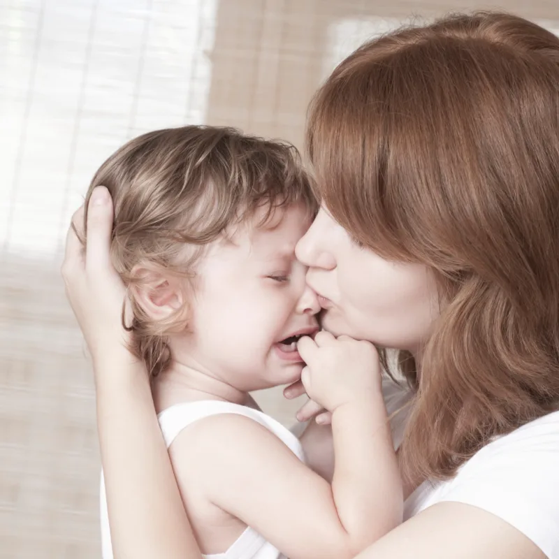 mother holding crying baby