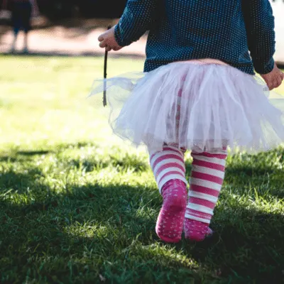 A young girl walking outside in the grass