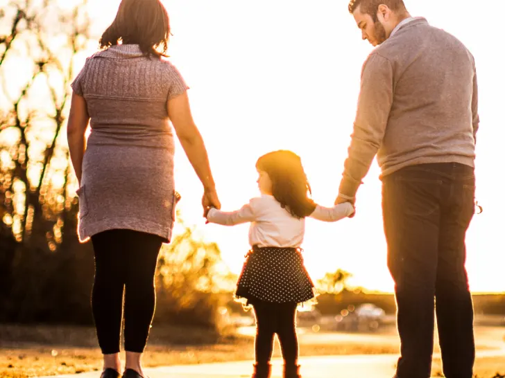 parents with their daughter standing on a road
