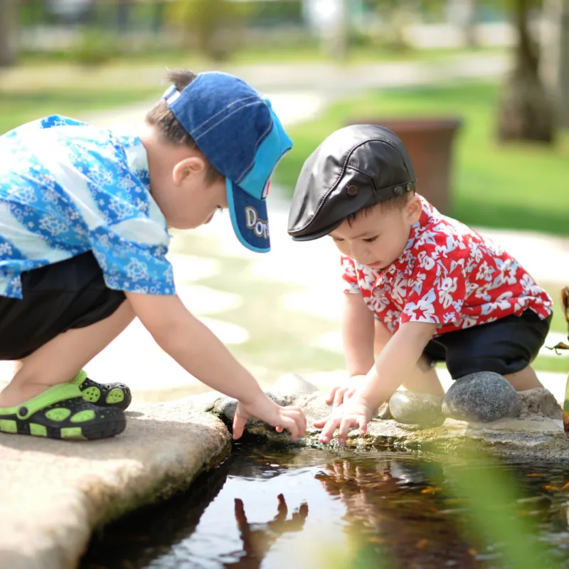 two young boys exploring a pond